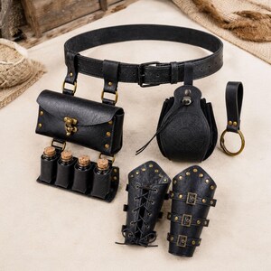 May include: A black leather belt set featuring a rectangular pouch with a brass latch, four small glass vials with cork stoppers, a circular embossed pouch, a separate ring holder, and two matching arm bracers with brass buckles and lacing.