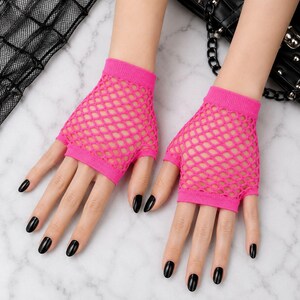 Pode incluir: Um par de luvas sem dedos de rede em rosa n&eacute;on brilhante, com um padr&atilde;o de losangos de malha larga e punhos el&aacute;sticos s&oacute;lidos no pulso e nos n&oacute;s dos dedos. As luvas s&atilde;o feitas de um material el&aacute;stico que cobre a palma e o dorso da m&atilde;o.