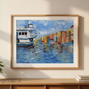 May include: Oil painting of a harbor scene with a white and blue boat on the left and colorful buildings on the right. The artwork is framed in a light wood frame and is displayed on a wooden surface.