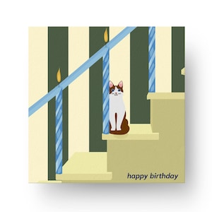 Puede incluir: Tarjeta de cumpleaños con un gato marrón y blanco en una escalera, velas azules y el texto "happy birthday". El fondo tiene rayas verticales verdes y crema.