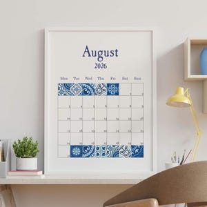 Puede incluir: Un calendario de pared enmarcado para agosto de 2026 con fondo blanco y texto azul oscuro. La cuadrícula del calendario incluye cuadrados decorativos con patrones de azulejos azules y blancos en la primera y última fila, en un marco blanco.
