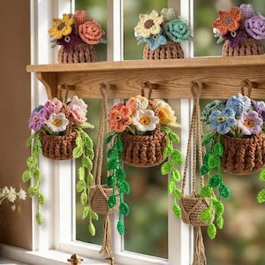 May include: Crocheted flower arrangements in brown baskets, some hanging and some on a wooden shelf. The flowers are in various colors, including yellow, orange, purple, and blue, with green leafy vines.