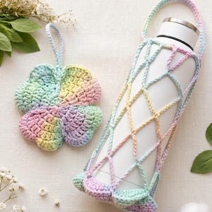 May include: A crochet pattern for a convertible lucky charm pouch and bottle holder. The image shows a four-leaf clover coaster and a bottle holder, both in pastel rainbow colours. The bottle holder is designed to fit a standard water bottle.