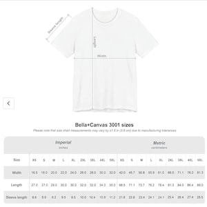 Puede incluir: Una camiseta blanca de manga corta acompa&ntilde;ada de una tabla de tallas para el modelo Bella+Canvas 3001. La tabla detalla el ancho, largo y largo de manga en pulgadas y cent&iacute;metros, indicando una tolerancia de fabricaci&oacute;n de 3,8 cm.