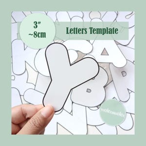 May include: A white letter 'Y' template, approximately 8cm in size, held by a hand. The image includes the text 'Letters Template' and a measurement indicator. The background features other letter templates.