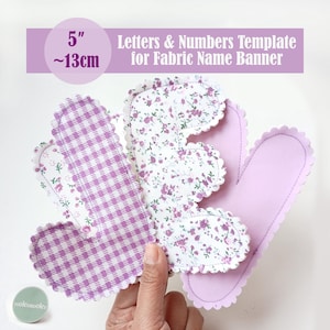 May include: A set of fabric letter templates for a name banner, measuring 5 inches in height. The pieces feature scalloped edges and various patterns, including purple gingham, a white floral print with pink flowers, and solid light purple.
