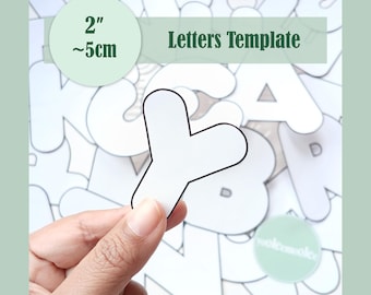 May include: A white paper letter Y cutout with a black outline, held against a background of various other white paper letter cutouts. A green label in the corner displays the text Letters Template and the measurement 2 inches or 5 cm.