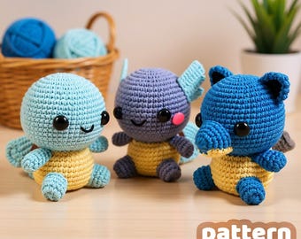 May include: Three handmade crochet turtle toys in blue, purple, and blue. Each turtle has a yellow belly and black eyes. The toys are sitting on a light brown surface. The text "pattern by VinCrafty" is in the bottom right corner.