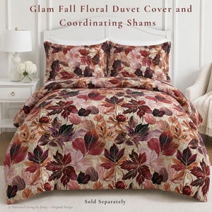 May include: A duvet cover and two matching pillow shams featuring a repeating pattern of autumn leaves in shades of deep burgundy, rust orange, and soft pink on a light beige background. The text Glam Fall Floral Duvet Cover and Coordinating Shams is visible.