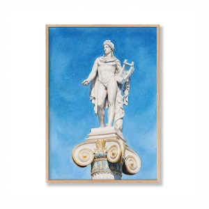 Puede incluir: Impresión enmarcada que muestra una pintura de acuarela de una estatua clásica de un hombre con una lira. La estatua es blanca, sobre un fondo de cielo azul. El marco es de madera clara.