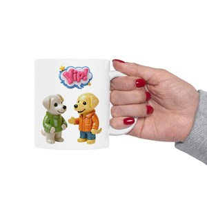 May include: A white ceramic mug with a black handle and the text "But First, Coffee" in a bold, black font. The mug is set against a blurred background, suggesting a cozy setting.