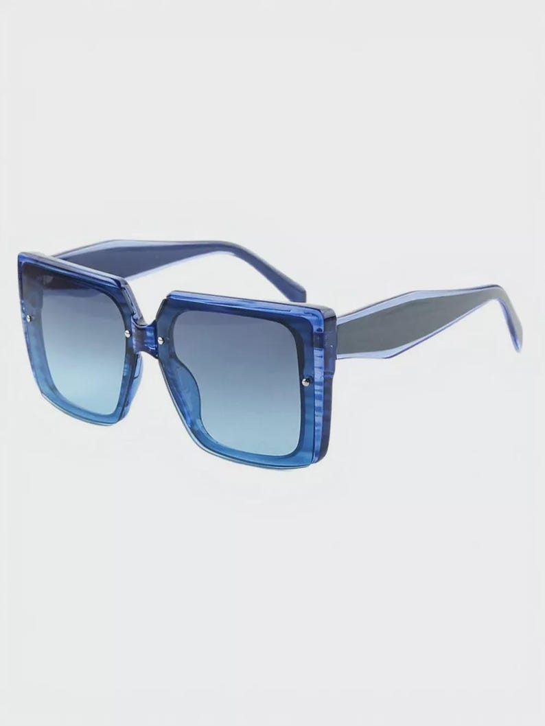 May include: Blue square sunglasses with a gradient lens. The frames are a translucent blue, and the arms are a darker blue. The lenses transition from a lighter blue at the bottom to a darker blue at the top.