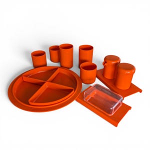 Op de afbeelding: Een oranje plastic kampeerset met borden, bekers en bakjes. De set bevat verdeelde borden, bekers van verschillende formaten en bakjes met deksel. De items zijn gerangschikt op een witte ondergrond.