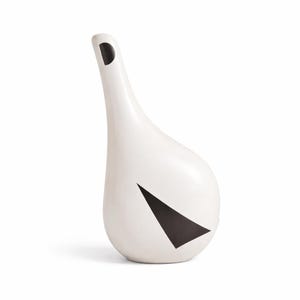 Pode incluir: Um regador de cerâmica branca com um bico longo e curvo e um design geométrico preto. O regador tem uma base arredondada e uma pequena abertura circular no topo do bico. O design preto tem a forma de um triângulo.