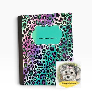 May include: A notebook featuring a vibrant leopard print pattern in shades of purple, teal, and black. A solid teal bracket-shaped label with a dotted line for writing is centered on the cover. A small square card shows a dog with a pink bow.