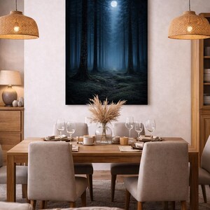 May include: A dining room with a large framed canvas of a dark forest scene with a bright moon. The wooden dining table is set with glasses and plates, and surrounded by beige upholstered chairs. Woven pendant lights hang above the table.