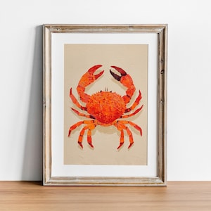 Op de afbeelding: Ingelijste kunstdruk met een levendige oranje krabillustratie. De krab heeft gedetailleerde scharen en poten, tegen een beige achtergrond. Het kunstwerk wordt gepresenteerd in een houten lijst, geschikt voor kust- of nautische decoratie.