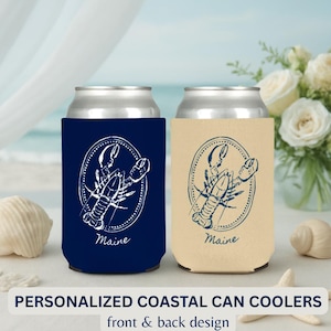 Pu&ograve; includere: Due portabicchieri, uno blu navy e uno beige, ciascuno con un disegno di aragosta bianca all'interno di una cornice ovale. La parola "Maine" &egrave; stampata sotto. Il testo "PERSONALIZED COASTAL CAN COOLERS" &egrave; in basso.