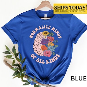 May include: A blue t-shirt with the text "NORMALIZE MINDS OF ALL KINDS" in pink. The design includes a brain graphic with colorful flowers. The word "BLUE" is at the bottom right.