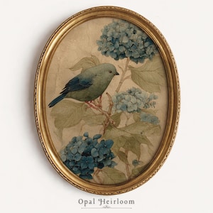 May include: An oval framed print depicting a blue bird on a branch with blue hydrangea flowers. The artwork has a vintage style, a gold frame, and the text "Opal Heirloom" at the bottom.