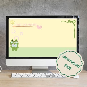 May include: A desktop computer displays a whimsical illustration with a green frog, a pink heart, and the text "TRUST THE PROCESS." A "download PDF" sticker is on the right. The screen has a light yellow and green background.