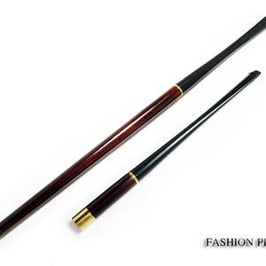 Może przedstawiać: Dwie fajki na białym tle. Jedna fajka jest długa i ciemnobrązowa ze złotą końcówką. Druga fajka jest czarna ze złotą końcówką. Tekst "FASHION PIPES" znajduje się w prawym dolnym rogu.