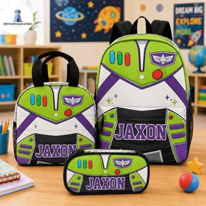 May include: A backpack, lunch bag, and pencil case set featuring a green, white, and purple space ranger design. Each item displays the name JAXON in purple lettering, along with red, blue, and green button graphics and a winged emblem.