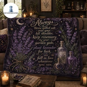 May include: A dark purple throw blanket featuring a large lavender bouquet, two glass apothecary bottles, and a crescent moon. The text reads: Always throw spilled salt over your left shoulder, keep rosemary by your garden gate, plant lavender for luck, and fall in love whenever you can.
