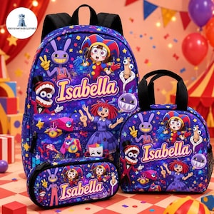 May include: A blue backpack, lunch bag, and pencil case set featuring a colorful cartoon print of characters and the name Isabella in yellow text. The items have black straps and zippers, with a repeating pattern of stars and geometric shapes.