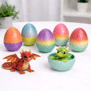May include: A collection of six colorful, textured dragon eggs with scale patterns, featuring a red dragon figurine standing outside and a green dragon figurine emerging from a light blue egg shell base. The eggs display gradients of orange, purple, blue, yellow, pink, and red.