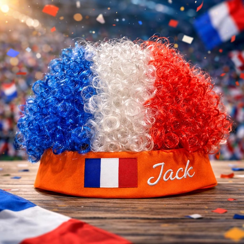 Peut inclure: Perruque fantaisie aux couleurs du drapeau fran&ccedil;ais : bleu, blanc et rouge. La perruque est fix&eacute;e sur un chapeau orange avec le drapeau fran&ccedil;ais et le nom "Jack" brod&eacute; dessus. Confettis et drapeaux en arri&egrave;re-plan.