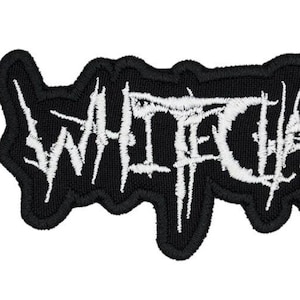 May include: A black embroidered patch featuring the word WHITECHAPEL in a jagged, stylized white font. The lettering has a distressed, sharp appearance with a thick black border surrounding the entire text design on a fabric base.