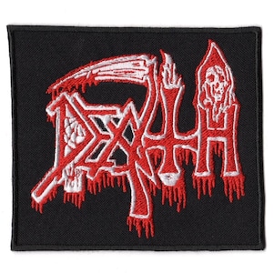 May include: A rectangular black embroidered patch featuring the word DEATH in a stylized red and white font. The design includes a scythe integrated into the lettering and a small skull figure positioned above the letter H, with red drips.