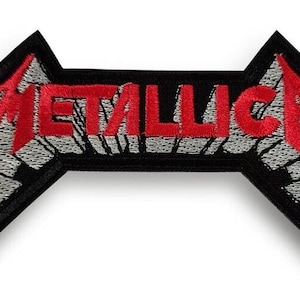May include: An embroidered fabric patch featuring the word METALLICA in a stylized red font with silver-grey shading. The lettering is set against a black background with a distinct angular shape, creating a bold and high-contrast design.