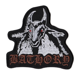 May include: A black embroidered patch featuring a white goat head with red eyes and the word BATHORY stitched in brown gothic lettering at the bottom. The patch has a die-cut shape with a black border and detailed white thread work.