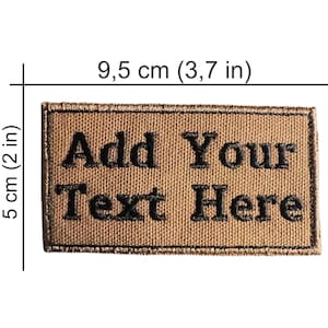 May include: A rectangular, tan patch with black embroidered text that reads "Add Your Text Here." The patch measures 3.7 inches wide and 2 inches high.