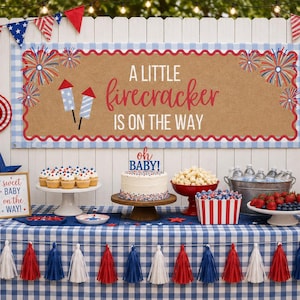 May include: A party display featuring a banner with the text A LITTLE firecracker IS ON THE WAY, a cake with an OH BABY! topper, cupcakes, strawberries, blueberries, and popcorn, all decorated in red, white, and blue with a gingham tablecloth.