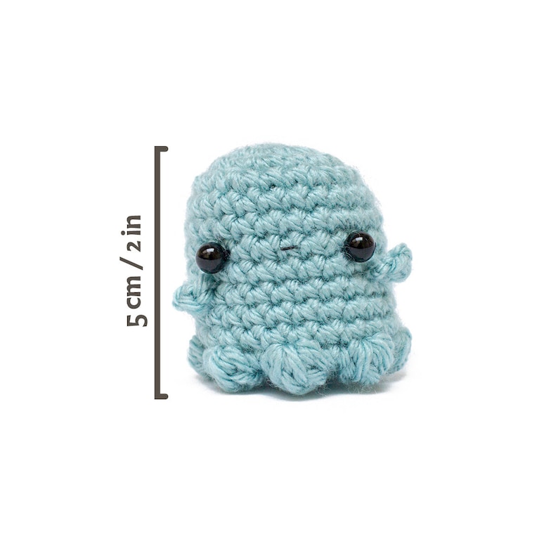 Op de afbeelding: Een kleine, gehaakte blauwe octopus met zwarte ogen. De octopus is ongeveer 5 cm hoog.