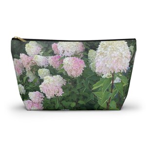 Puede incluir: Un primer plano de un arbusto de flores de hortensia blancas y rosadas. Las flores están en plena floración y están dispuestas en un racimo. El fondo es un verde borroso.
