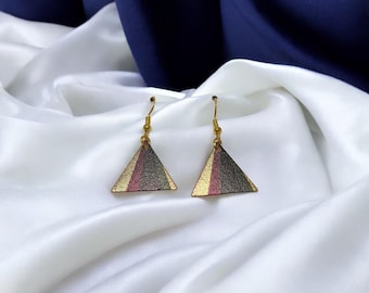 May include: A pair of gold triangle earrings with a black, gold, and pink striped pattern.