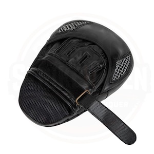 May include: Black leather boxing focus mitt with a mesh ventilation area and a hook-and-loop strap for secure fit. The mitt features a padded striking surface and a hand compartment with finger slots.