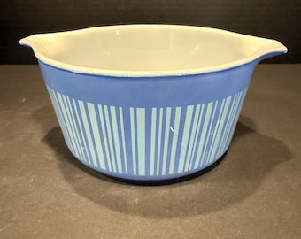May include: A blue and white Pyrex bowl with a light blue interior. The exterior features a blue background with vertical stripes in a lighter shade of blue. The bowl has two handles and is likely used for cooking or serving.