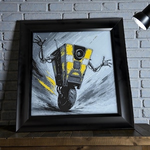 May include: Framed artwork featuring a yellow and black robot character with outstretched arms and a single wheel. The robot has a camera eye and antenna. The background is gray with yellow streaks, and the frame is black.