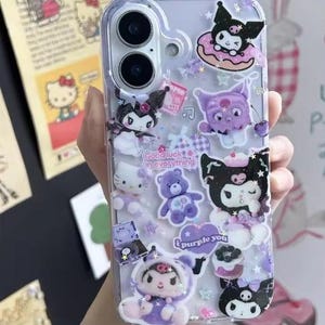 May include: Clear phone case decorated with various cartoon characters in shades of purple, white, and black. The case features a Hello Kitty, a purple teddy bear, and the text "Good luck in everything" and "I purple you".