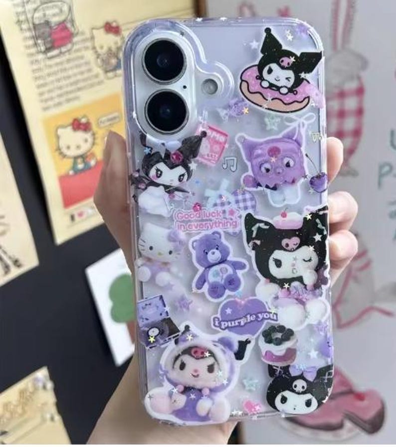 May include: Clear phone case decorated with various cartoon characters in shades of purple, white, and black. The case features a Hello Kitty, a purple teddy bear, and the text "Good luck in everything" and "I purple you".