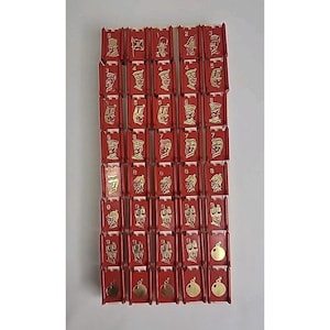 May include: A collection of red game tiles with gold-colored illustrations and numbers. Each tile features a unique design, with numbers from 1 to 9. The tiles are arranged in a grid pattern.