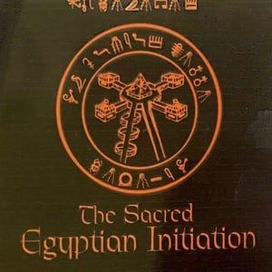 May include: Dark brown surface with orange hieroglyphs and a circular emblem. The emblem features a central structure with a spiral and surrounding symbols. Text reads "The Sacred Egyptian Initiation".