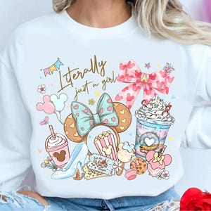 May include: A white ceramic mug with a black handle and the text "But First, Coffee" in a black, bold font. The mug is on a white surface.