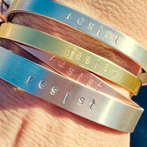 Hand stamped “resist” cuff bracelet in aluminum, copper, or brass
