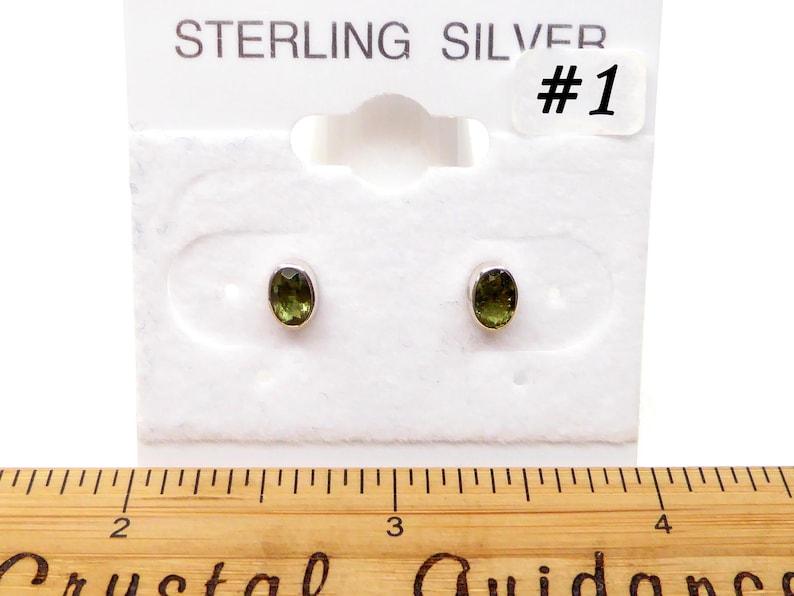 May include: Sterling silver earrings with green oval gemstones. The earrings are on a white card with the text "STERLING SILVER #1".